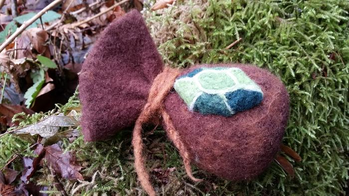 brown zelda wallet with green rupee lying on moss